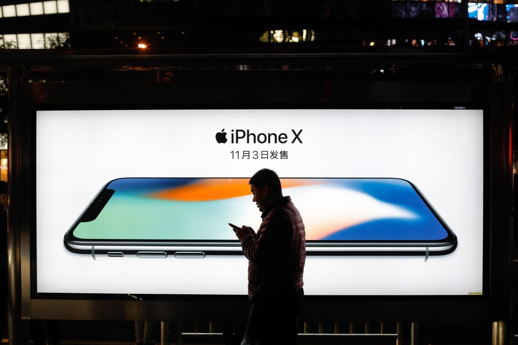 A man walks past an iPhone X advertisement in Beijing. Photo: EPA-EFE