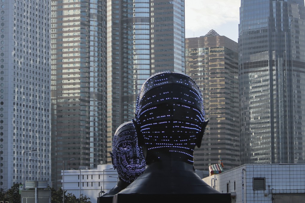 Artist Viktor Vicsek’s work Talking Heads is displayed at the Central harbourfront to the backdrop of skyscrapers in Hong Kong’s financial district in February. Take-up of office space in Central contracted quarter-on-quarter. Photo: Winson Wong