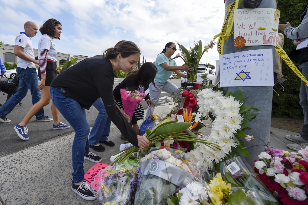 A group of Poway residents bring flowers and cards to a memorial outside of the Chabad of Poway synagogue. Photo: AP Photo