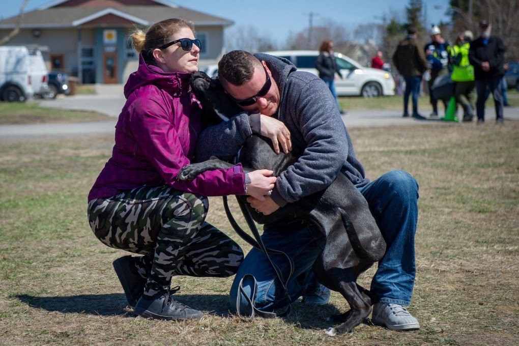 Anne-Marie St-Louis and Robert Tourangeau embrace their dog Harley after he was rescued in the Sainte-Marthe-sur-le-Lac, Quebec on Monday. Photo: AFP