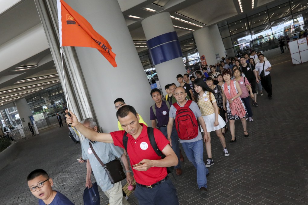 Mainland Chinese tourists following their tour leader at the Hong Kong Boundary Crossing Facilities of Hong Kong-Zhuhai-Macau bridge, Chek Lap Kok, on Wednesday. Photo: Felix Wong