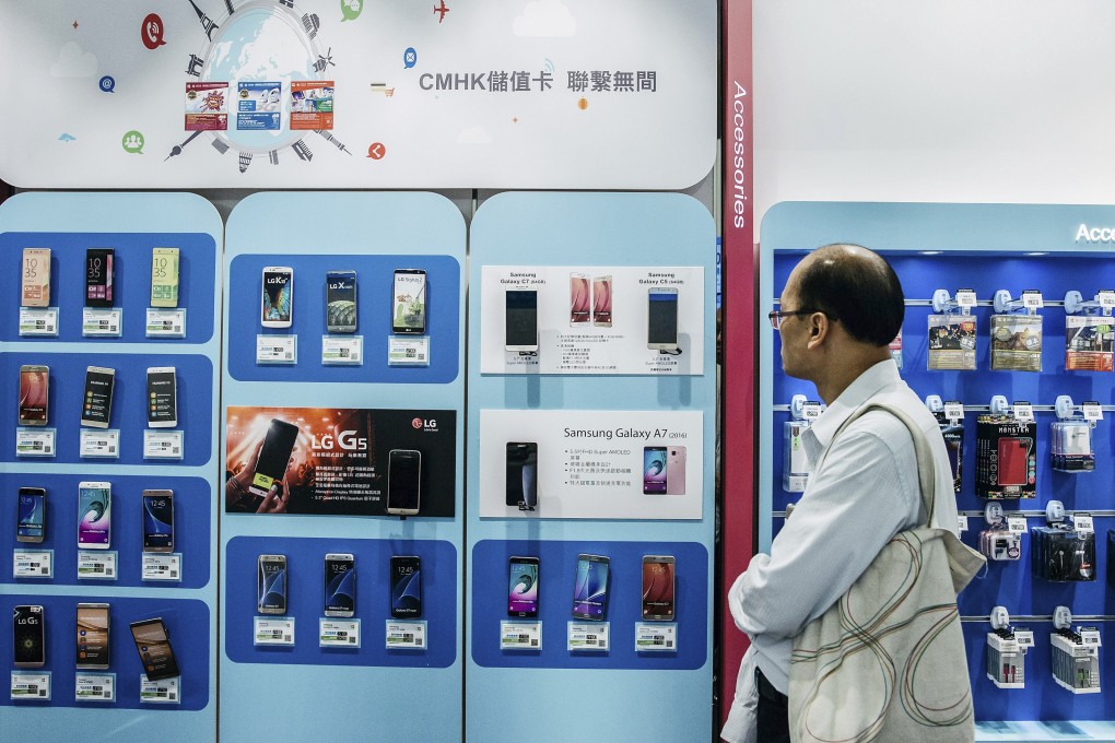 A customer looks at smartphones on display at a store in Hong Kong. Photo: Bloomberg