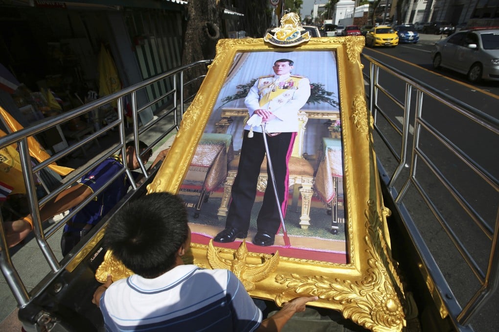 Thai workers prepare to transport a giant portrait of Thailand’s King Maha Vajiralongkorn. Photo: AP