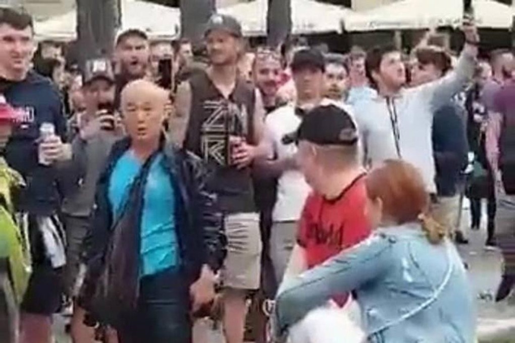 An elderly Asian man looks on in shock after being pushed into a fountain at a Barcelona square by a Liverpool fan. Photo: Twitter