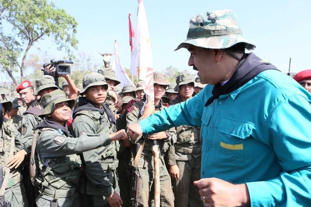 Venezuela's President Nicolas Maduro fist bumps with a soldier during his visit to a military training center in El Pao, Venezuela. Photo: Handout via Reuters
