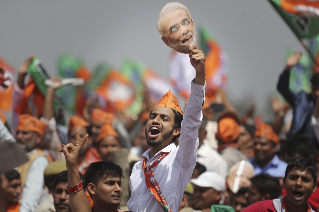 A BJP supporter shouts slogans as he holds up a mask of Indian Prime Minister Narendra Modi during an election rally in Meerut, India, on March 29. Photo: AP
