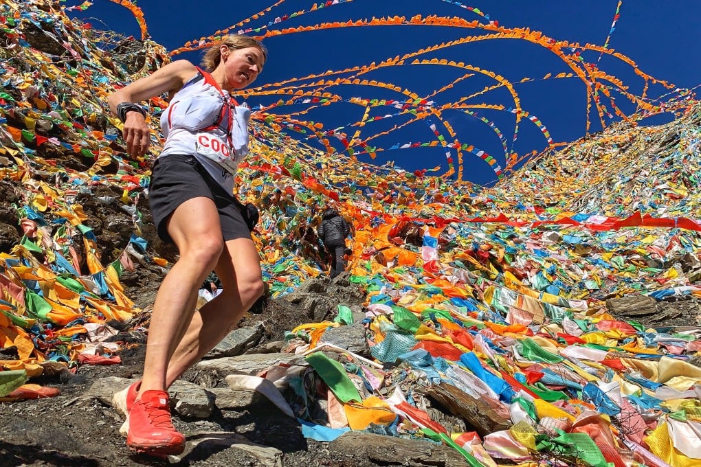 Megan Kimmel is surrounded by Tibetan flags on her way to victory in the Yading Skyrun. Photo: MRSWS/Albert Jorquera