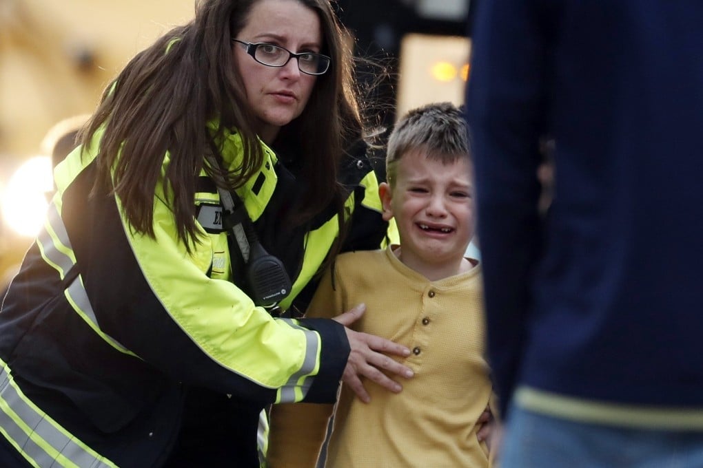Officials guide students off a bus and into a recreation centre where they were reunited with their parents after a shooting at a suburban Denver middle school. Photo: AP