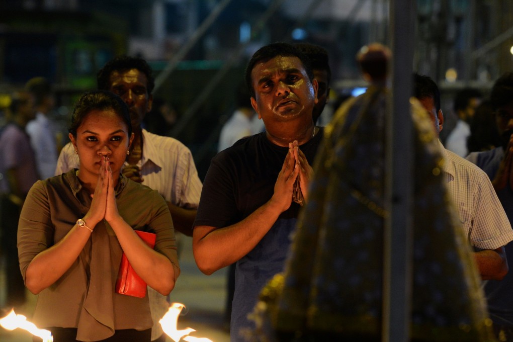 Sri Lankan Catholic devotees pray at St Anthony’s church after it was partially opened. Photo: AFP