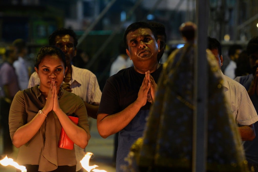 Sri Lankan Catholic devotees pray at St Anthony’s church after it was partially opened. Photo: AFP
