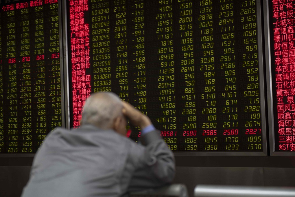 An investor looks at stock price movements on a screen at a securities company in Beijing. Photo: AFP