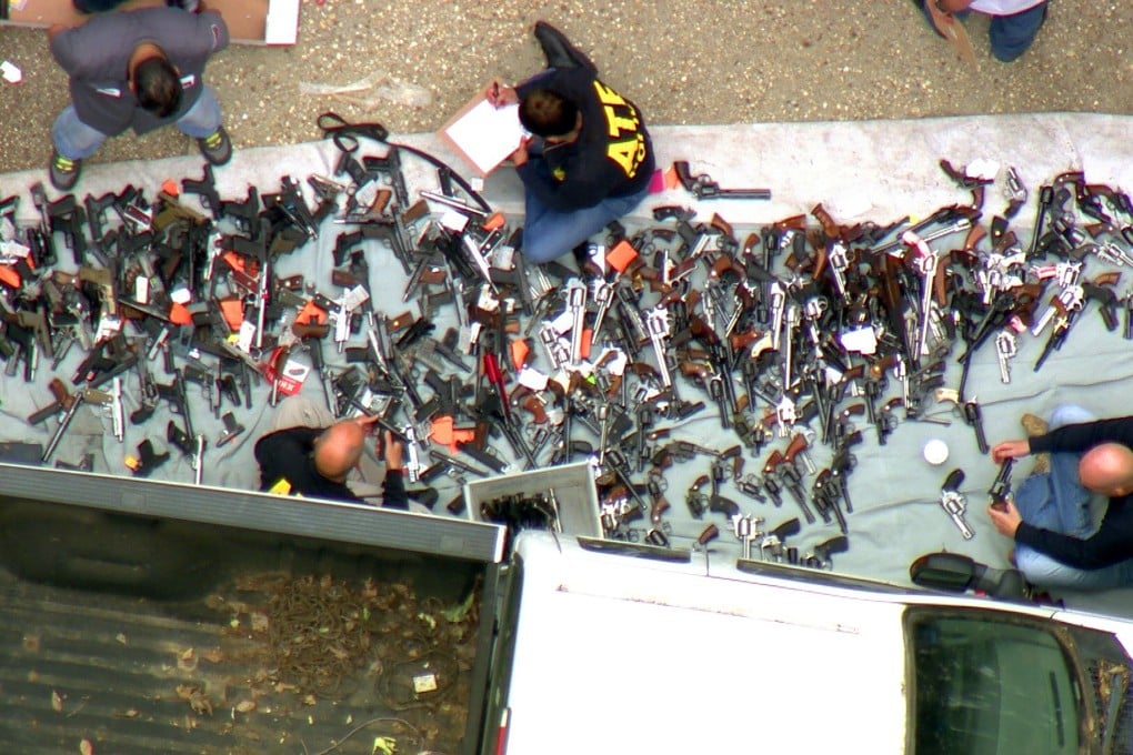 Investigators from the US Bureau of Alcohol, Tobacco, Firearms and Explosives and the police inspecting a large cache of weapons seized at a home in the affluent Holmby Hills area of Los Angeles on Wednesday. Photo: KCBS/KCAL-TV via AP