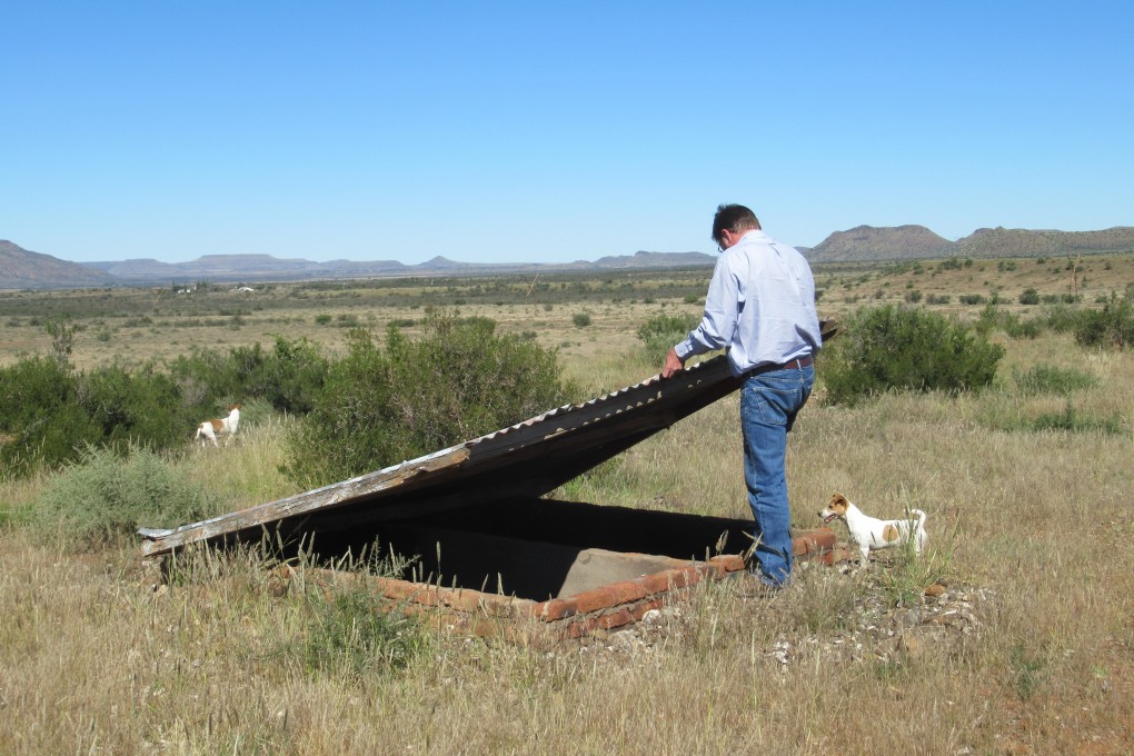 Simon Roche opens his ‘grave’, which is stocked full of emergency supplies, on a farm in the Northern Cape. Photo by Kate Bartlett