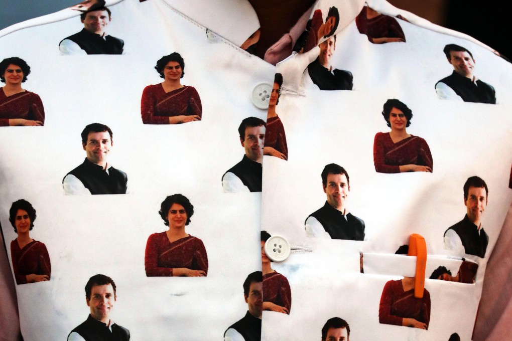 A Congress supporter wearing a jacket with pictures of Rahul Gandhi and his sister Priyanka Gandhi at a rally in New Delhi. Photo: EPA