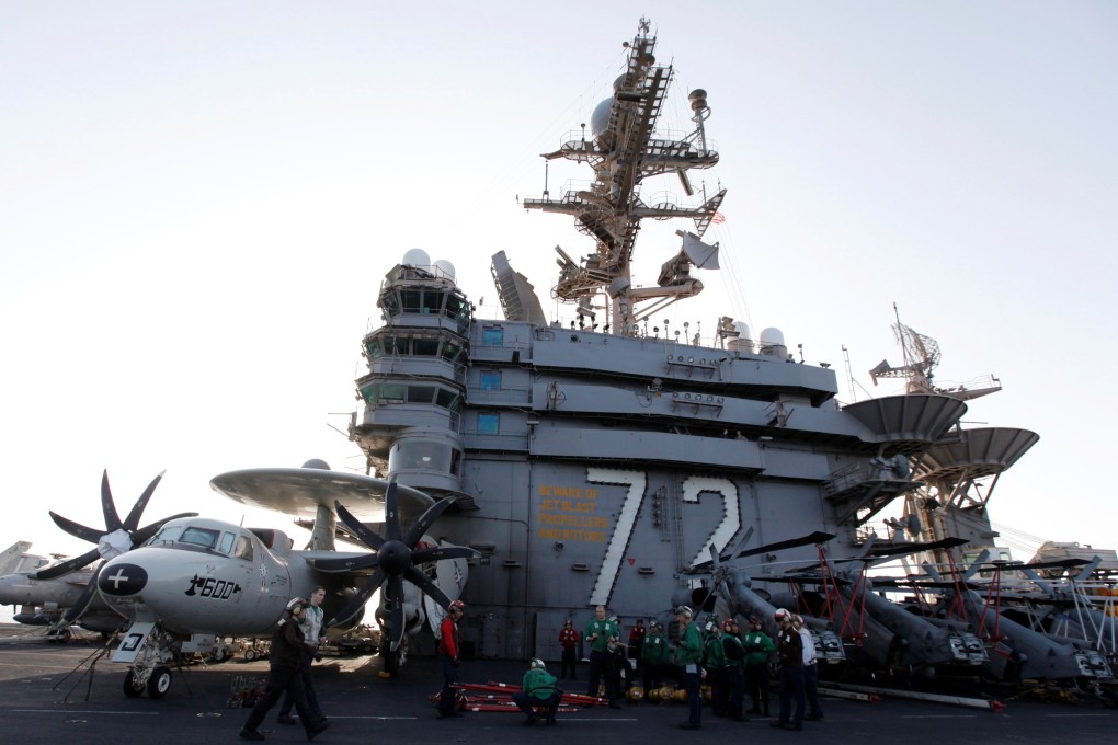 Flight deck personnel stand on the flight deck on board the Nimitz-class aircraft carrier USS Abraham Lincoln (CVN 72) as it patrols the Arabian Gulf. Photo: Reuters