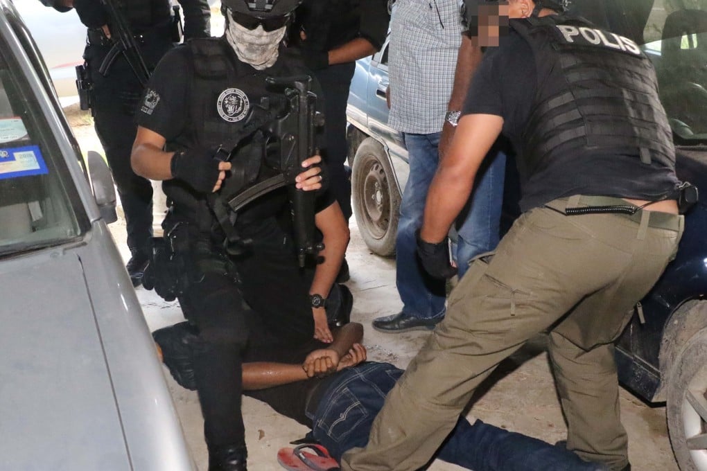 Malaysian anti-terror police handle one of the suspects during a sting operation last week. Photo: Handout