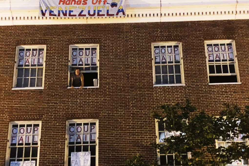 An activist who supports Venezuelan President Nicolas Maduro stands by the window of the country’s embassy in Washington. Photo: AP