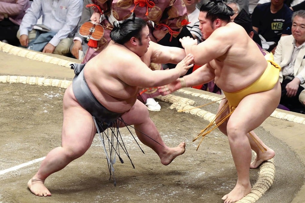 Ozeki Takakeisho (left) shoves out Maegashira Endo on the first day of the Summer Grand Sumo Tournament in Tokyo on Sunday. Photo: Japan News-Yomiuri