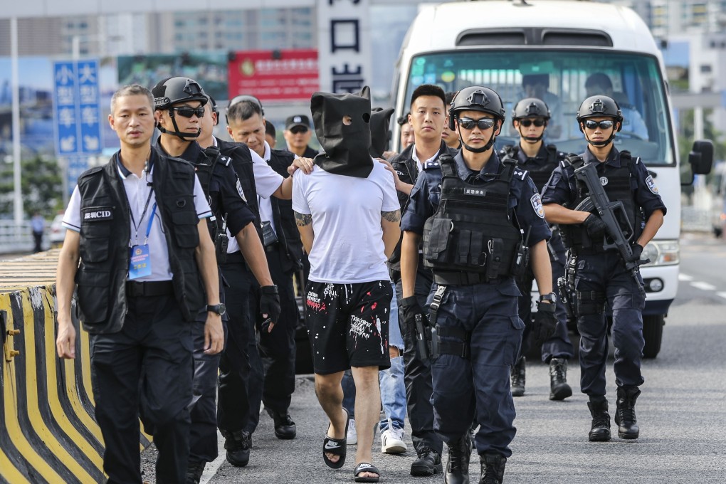 Guangdong Police hand over three suspects in a goldsmiths robbery case to Hong Kong Police at Huanggang port. Photo: Edward Wong