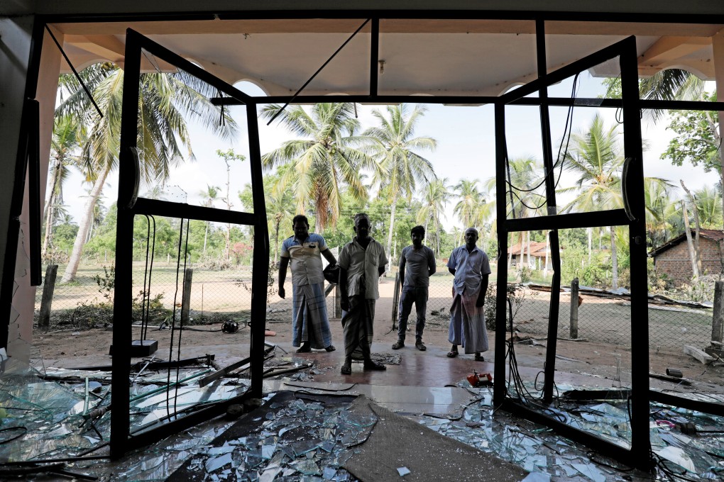 Muslim men stand in front of the Abbraar Masjid mosque after a mob attack in Kiniyama, Sri Lanka, on Monday. Photo: Reuters