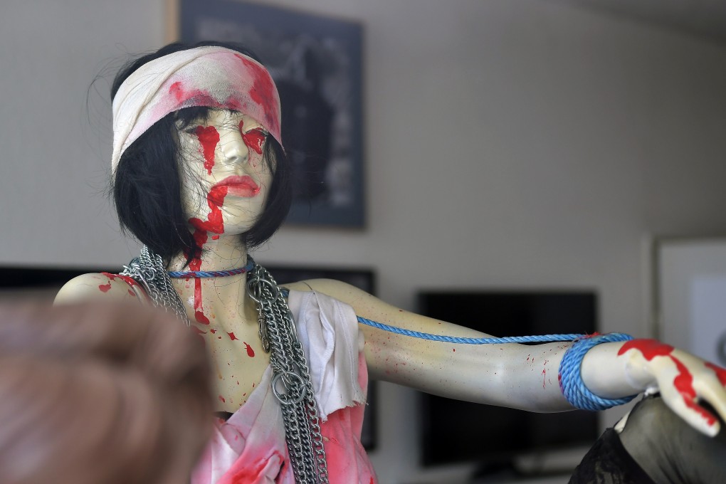 A mannequin sits on a table photographed through a window of the medieval business of Torsten W. in Hachenburg, Germany. Photo: EPA-EFE