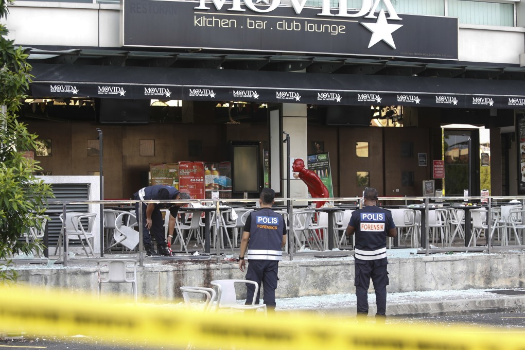 Forensic personnel inspect the site of a grenade attack at a bar and restaurant in Puchong, outside Kuala Lumpur, in 2016. Photo: AP