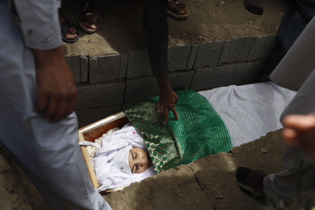 Relatives take a final look at the face of Mena Mangal before she is buried. Photo: EPA