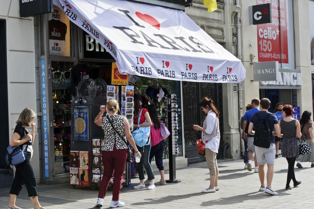 Tourists buying postcards in Paris, France. Photo: Alamy