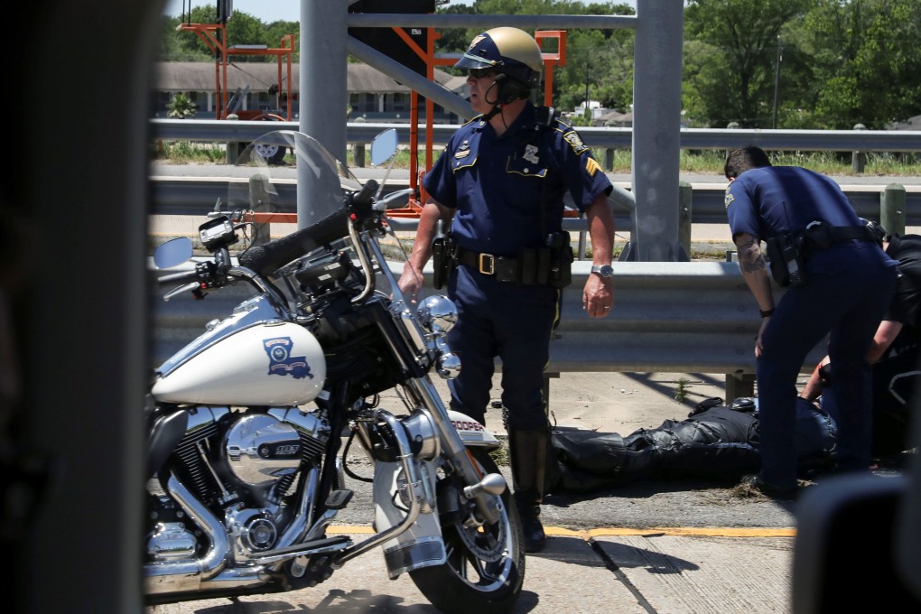 Police officers tend to a fallen colleague after an accident involving US President Donald Trump's motorcade on Tuesday. Photo: Reuters