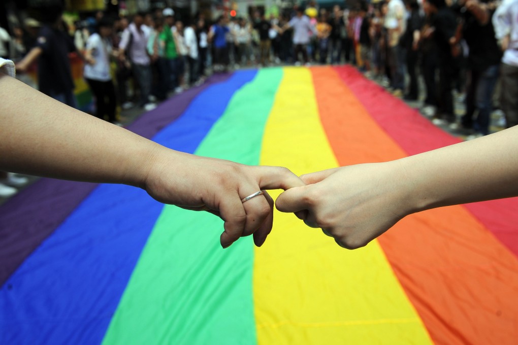 Activists form a human chain around a rainbow flag to mark the fourth annual International Day Against Homophobia in Hong Kong on May 18, 2008. Photo: AFP