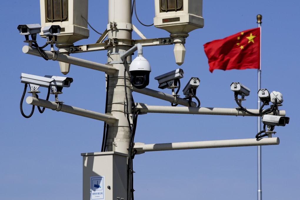 A Chinese national flag flutters near the surveillance cameras mounted on a lamp post in Tiananmen Square in Beijing, March 15, 2019. Photo: AP