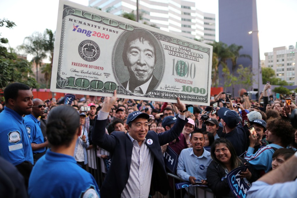 US Democratic presidential candidate Andrew Yang hoists a supporter's sign after speaking at a rally in downtown Los Angeles, California, US, April 22, 2019. REUTERS/Lucy Nicholson