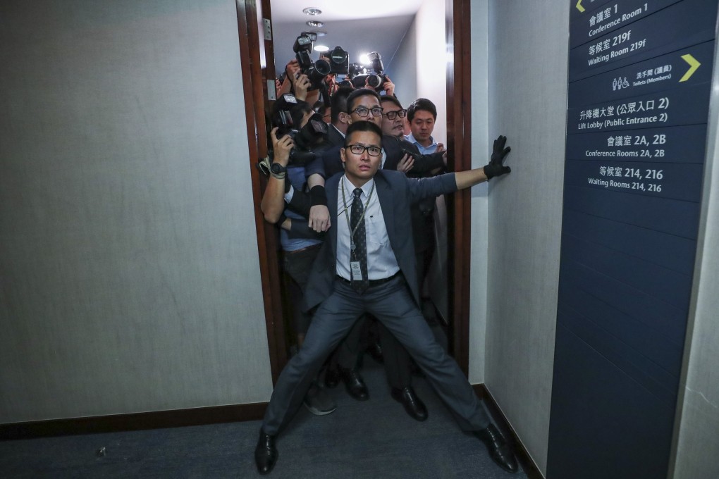 A security officer tries to stop reporters from entering the bills committee meeting. Photo: Sam Tsang