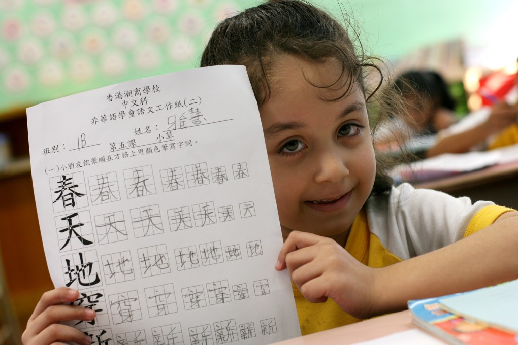A Primary One pupil of Pakistani origins holds up her Chinese schoolwork. Photo: K.Y. Cheng