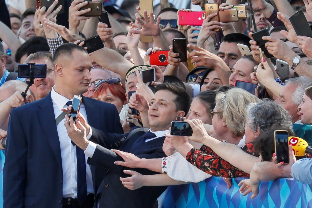 Ukraine's President-elect Volodymyr Zelenskiy takes a selfie with his supporters as he walks to take the oath of office. Photo: Reuters