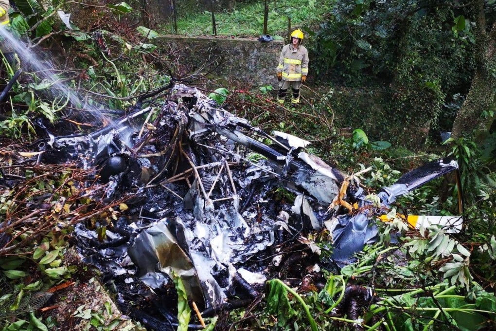 Firefighters tend to the wreckage following a helicopter crash near Kadoorie Farm in Hong Kong on Sunday evening. Photo: Hong Kong Police Force