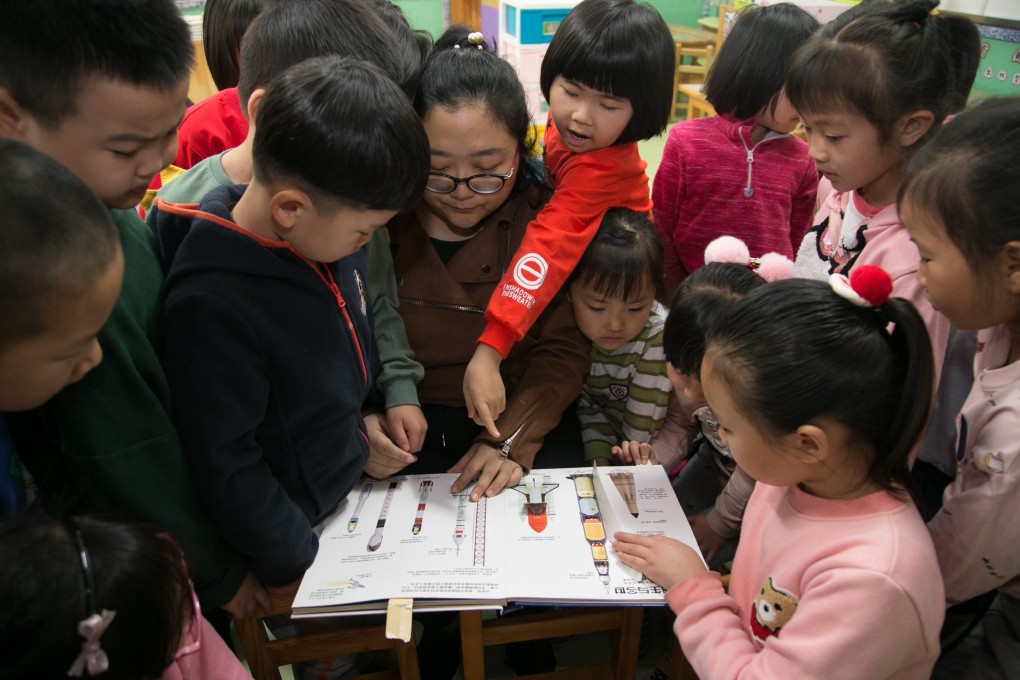 A kindergarten teacher in Mentougou district of Beijing teaches children about space. Photo: Xinhua