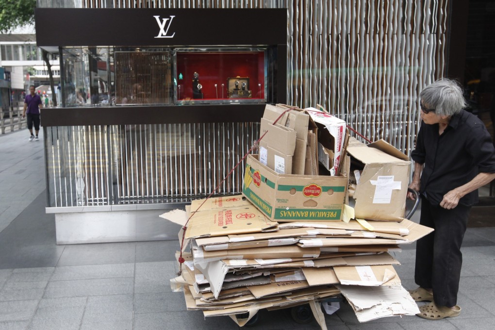 An elderly low-income earner pushes a trolley with cardboard bundles in Hong Kong's Central district. Among Asian cities, Hong Kong ranked below Tokyo, Singapore, Seoul and Bangalore in terms of quality of life. Photo: EPA