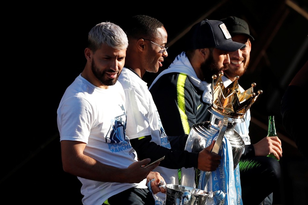Manchester City’s Sergio Aguero, Raheem Sterling and teammates celebrate with the English Premier League trophy on a bus during the parade. Photo: Reuters