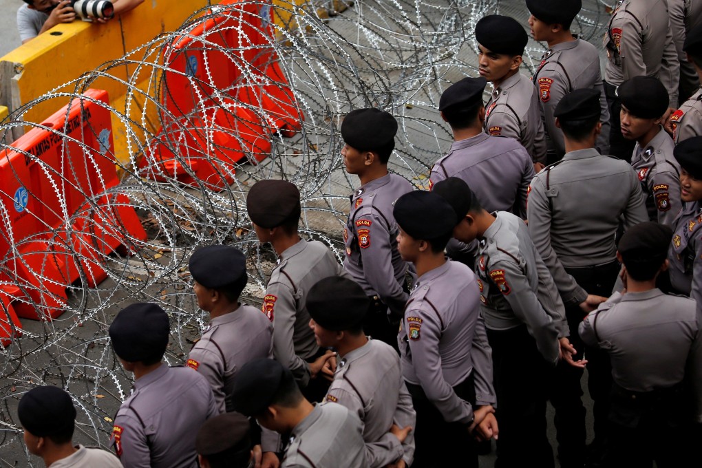 Indonesian police officers stand guard during a May Day rally near the National Monument (Monas) in Jakarta. Photo: Reuters
