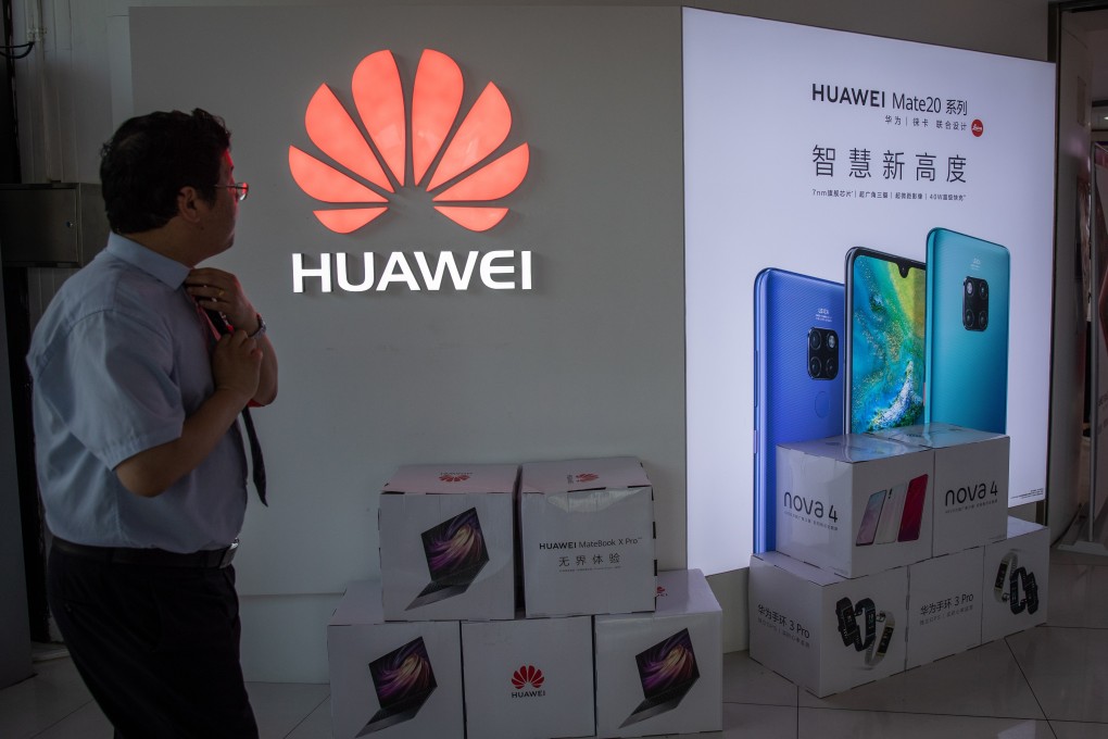A man walks next to a Huawei logo in a shopping centre in Beijing on Monday. Photo: EPA-EFE