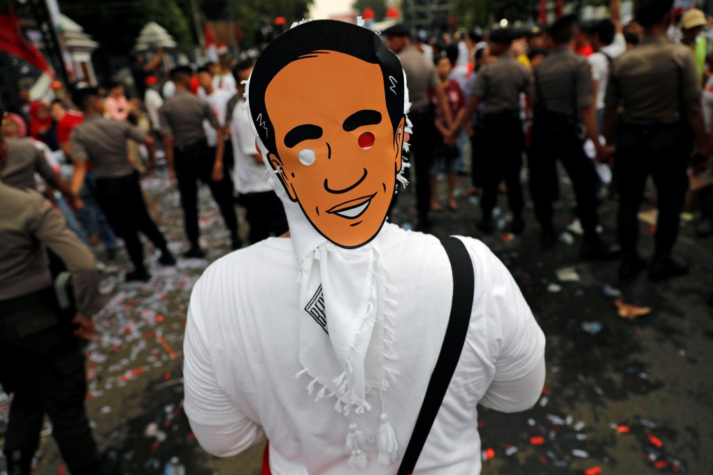 A supporter wears a mask of Indonesian President Joko Widodo. Photo: Reuters