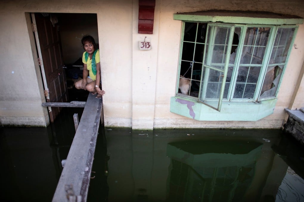 A woman looks out of her flooded house in Mabalacat, Pampanga. Photo: AFP