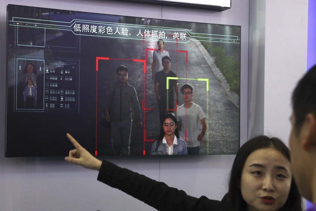 A sales woman introduces human identification technology from state-owned surveillance equipment manufacturer Hikvision on a monitor at Security China 2018 in Beijing. Photo: AP