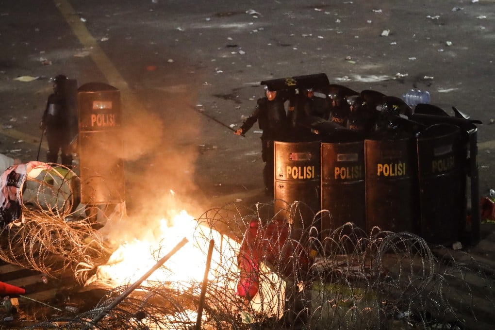 Indonesian riot police officers move to disperse the crowd during a protest outside the Election Supervisory Board building in Jakarta on May 22. Photo: EPA-EFE