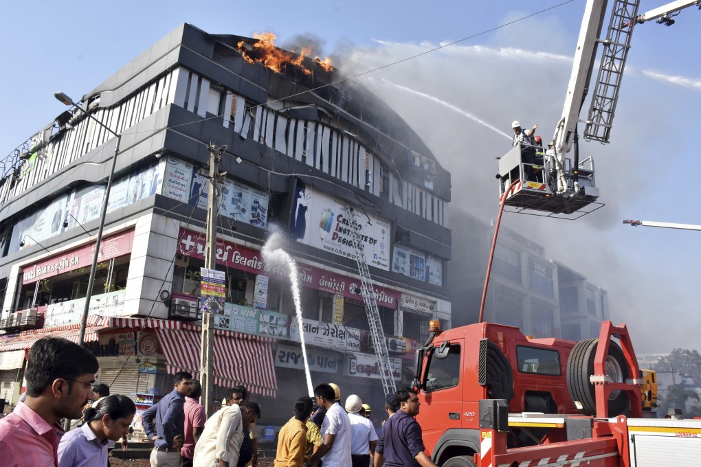 Firefighters work to douse flames on a building in Surat, in the western Indian state of Gujarat. Photo: AP