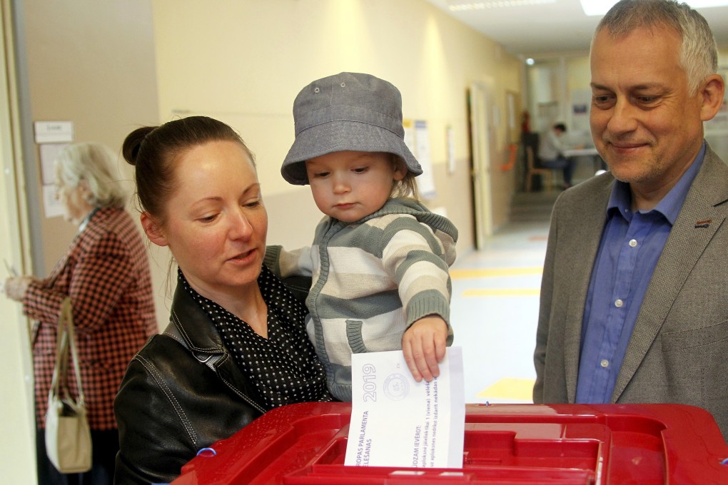 Family members cast their vote at a polling station in Riga, Latvia. Photo: EPA-EFE