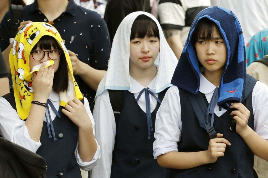 Students in Kyoto try to beat the heat with wet towels. Photo: Kyodo