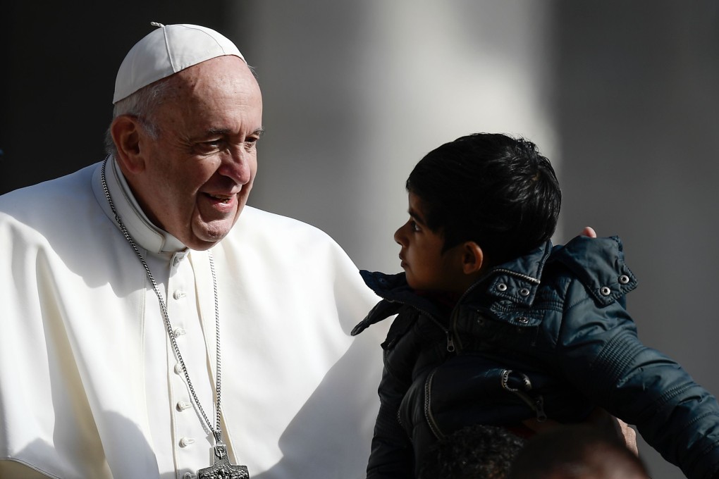 Pope Francis blesses a child as he arrives for the weekly general audience on May 8 at St Peter's square in the Vatican. Photo: AFP