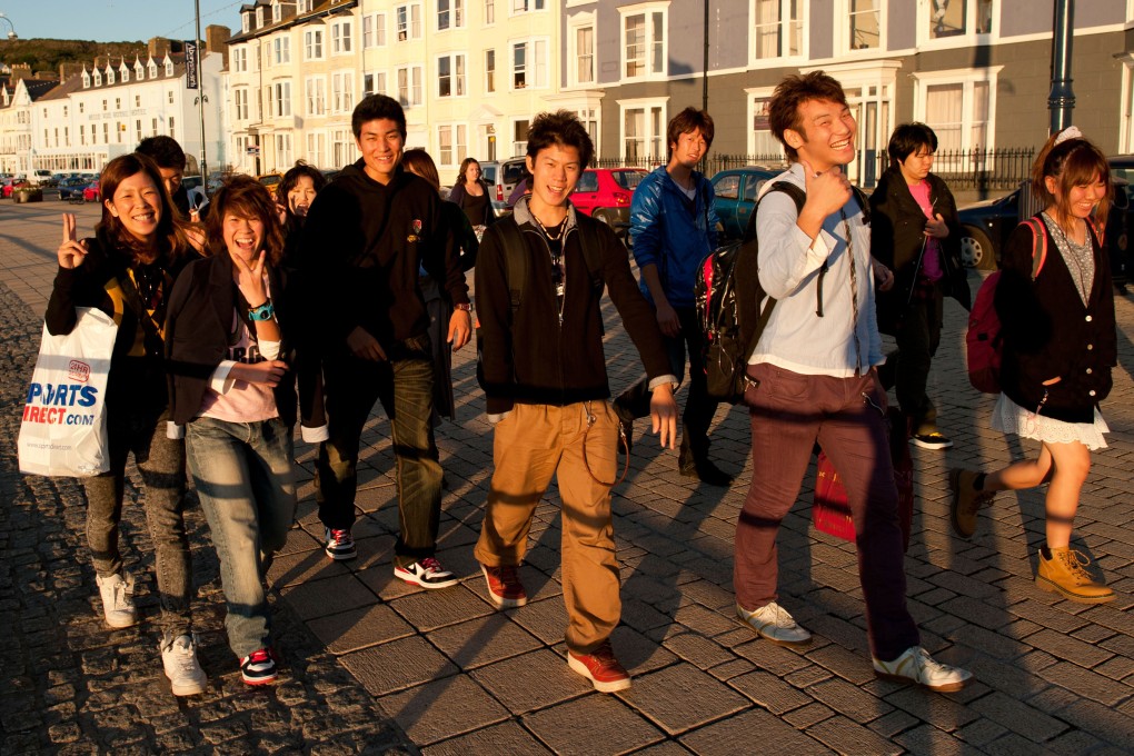 A group of overseas Chinese university students on Aberystwyth promenade, Wales UK. Photo: Alamy